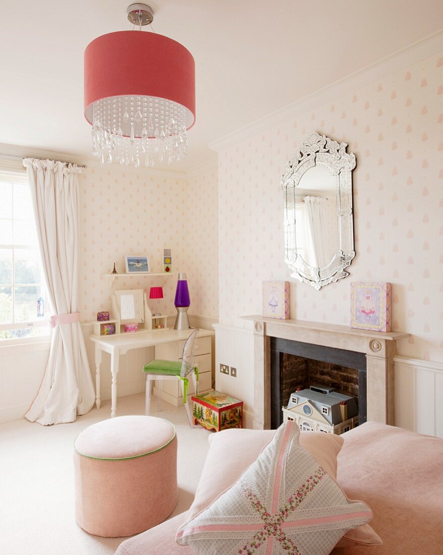 Classic furnishings in child's bedroom with desk, pouffe and fireplace
