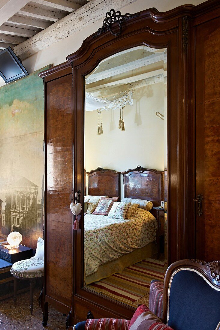 Antiker Kleiderschrank mit Spiegeltür in traditionellem Schlafzimmer