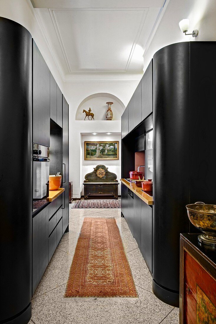 Moderne, schwarze Schrankeinbauten mit abgerundeten Ecken in offener Küche, in traditionellem Ambiente