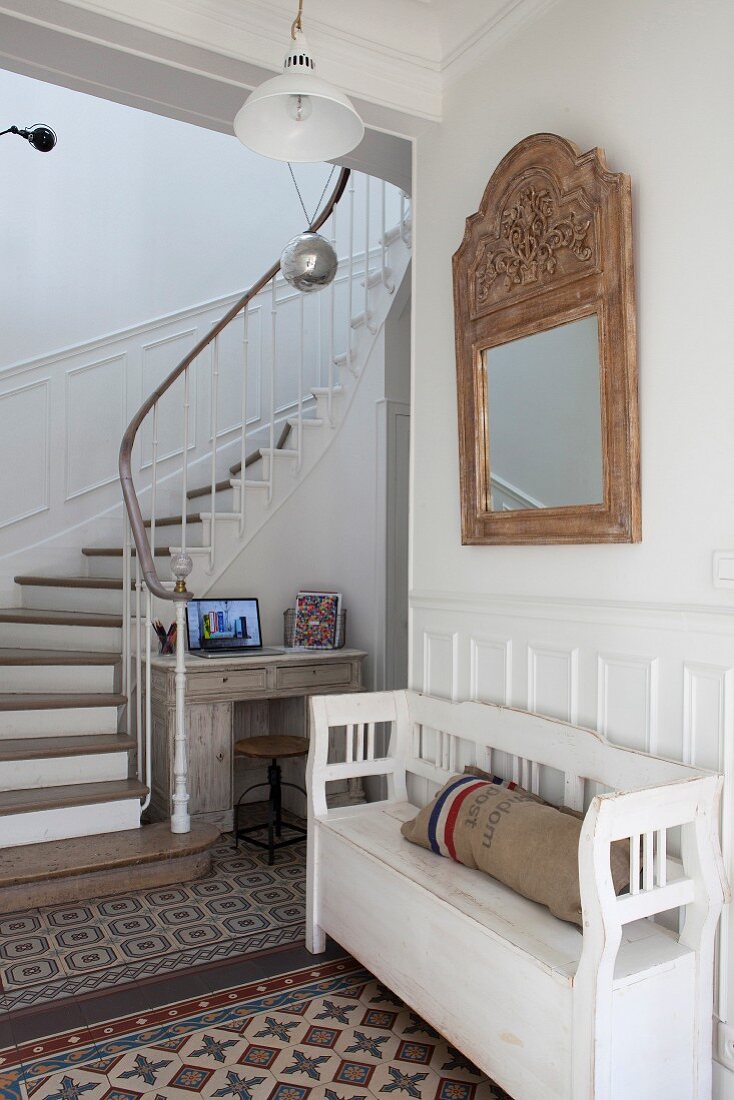 Flurbereich mit dekorativem Mosaikfliesenboden und gewendeltem Treppenaufgang