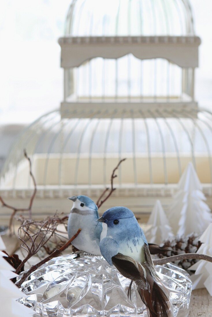 Zwei Dekovögel auf Kristallglasschale, im Hintergrund Vintage Vogelkäfig