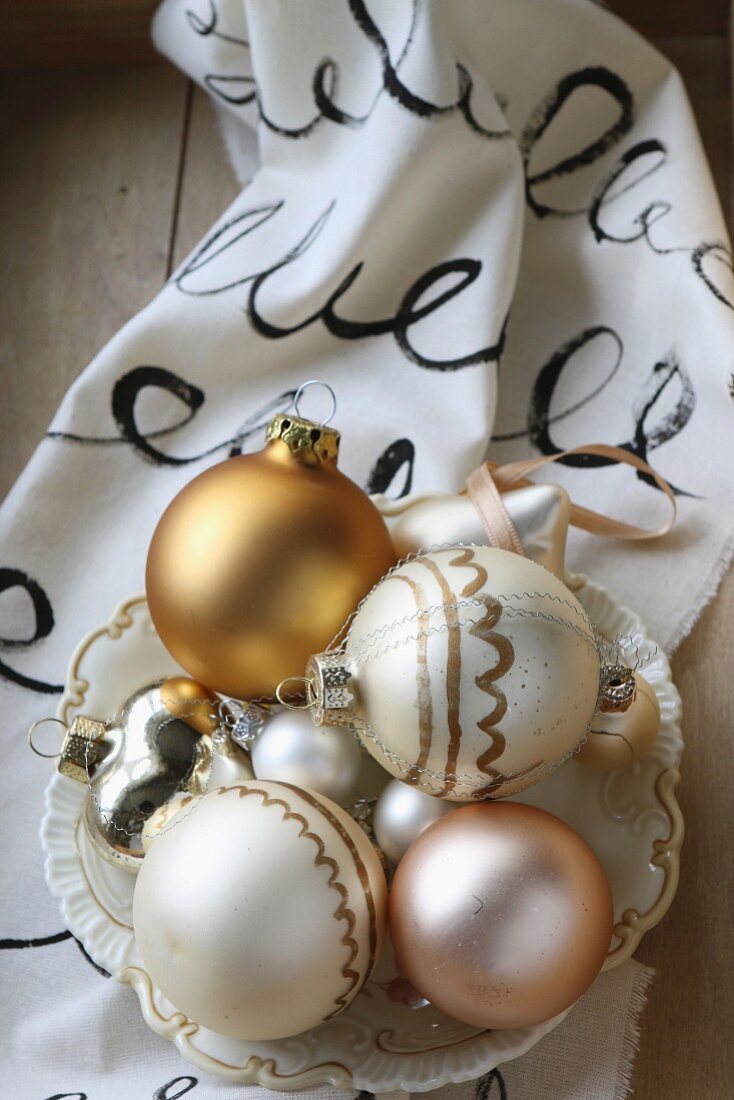 Weihnachtskugeln in Vintage Schale auf handbemaltem Tuch