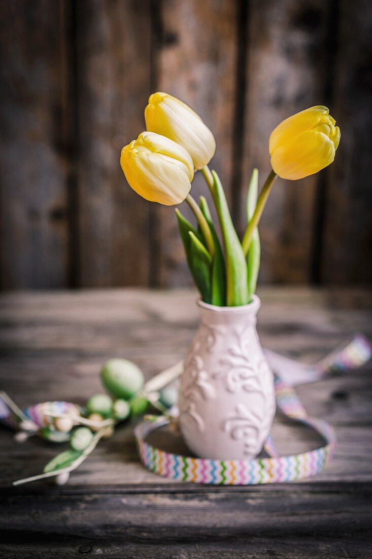 Drei gelbe Tulpen in kleiner Keramikvase – Bild kaufen – 11399331 ❘  living4media