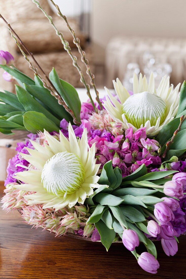 Arrangement of king proteas, willow catkins, tulips and sweet peas