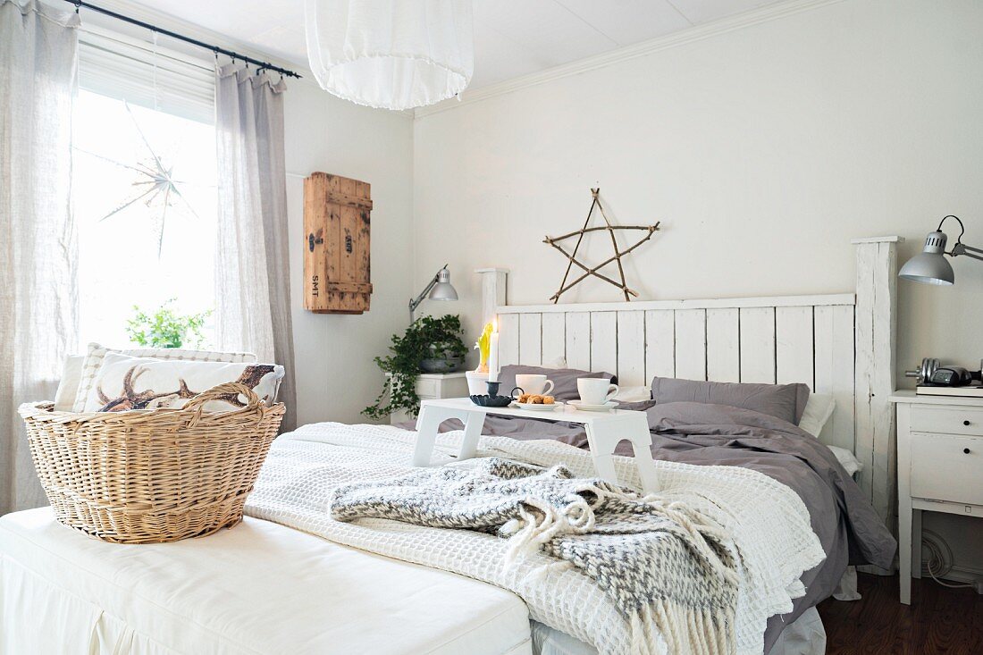 Gemütliches Schlafzimmer in winterlichem Weiß mit Frühstückstablett