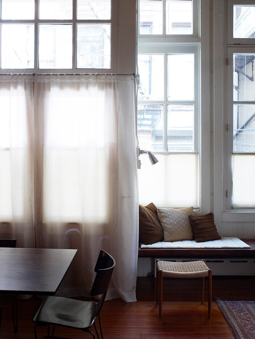 Dining table and bench against wall made from lattice windows