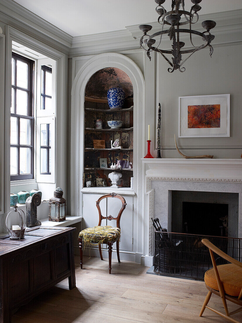 Arched niche next to open fireplace in stucco wall