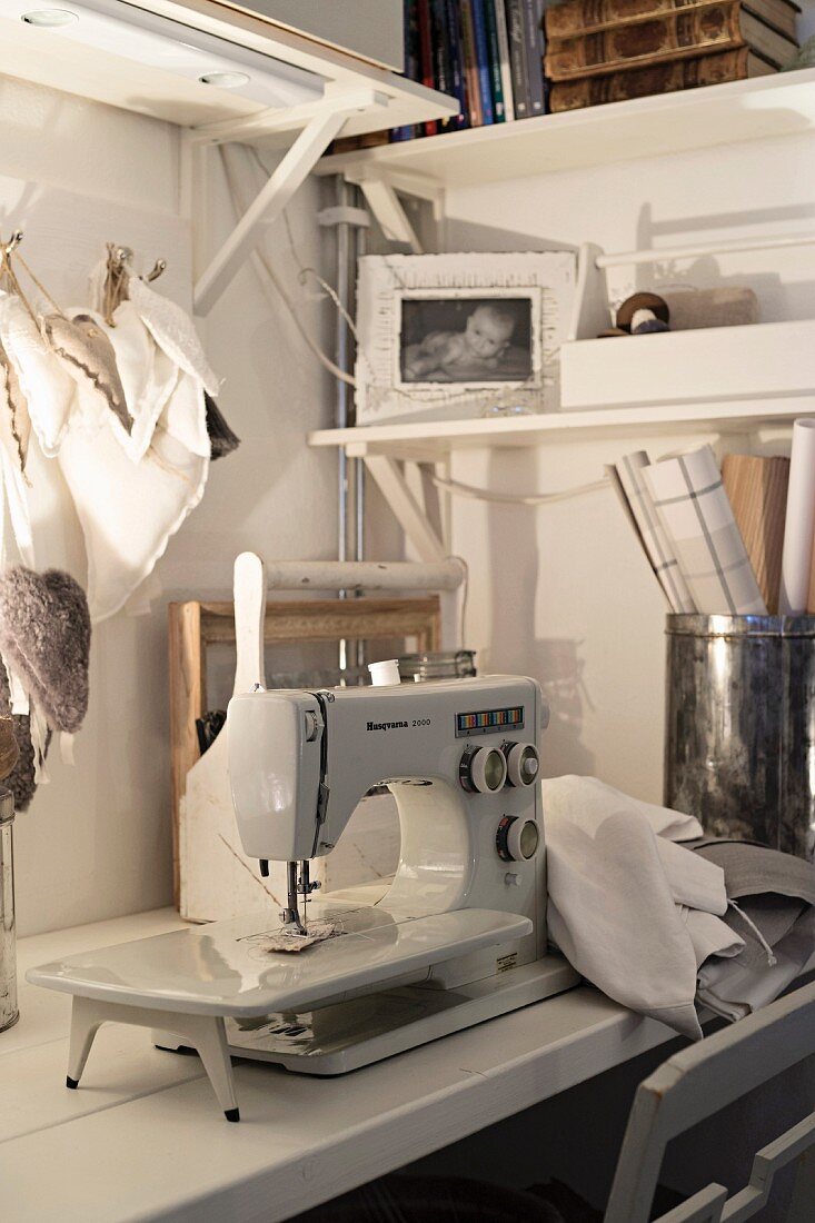 Old sewing machine and fabric love-hearts on workbench