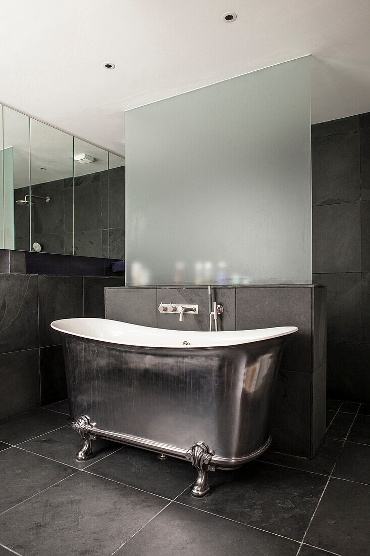 Vintage-style, free-standing silver bathtub in grey bathroom