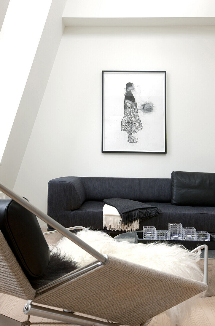 Fur blanket on armchair and black sofa in modern living room