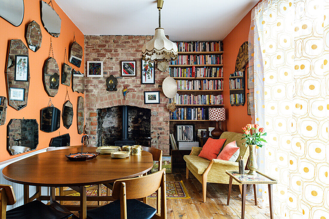 Collection of mirrors and log burner in fireplace in dining room