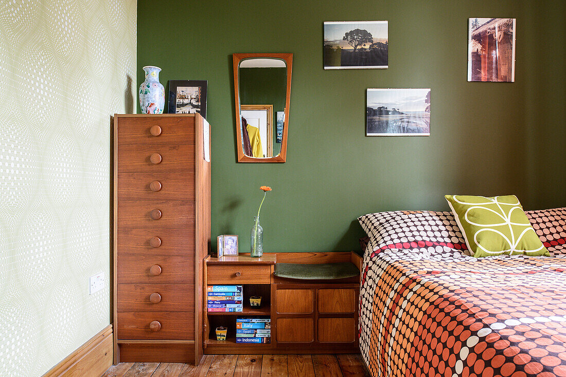 Retromöbel und dunkelgrüne Wand im Schlafzimmer