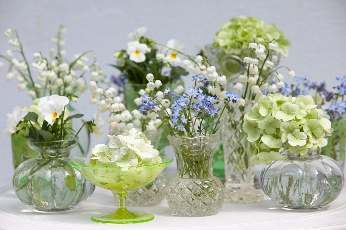 Arrangement von verschiedenen Miniväschen mit Frühlingsblumen