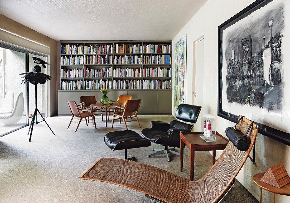 Wohnzimmer mit Lounge Chair, Essplatz und Bücherwand