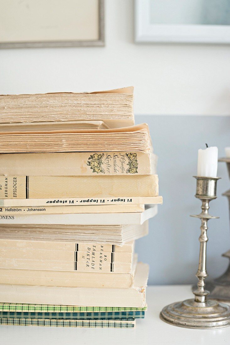 Bücherstapel und Silber Kerzenhalter auf Ablage