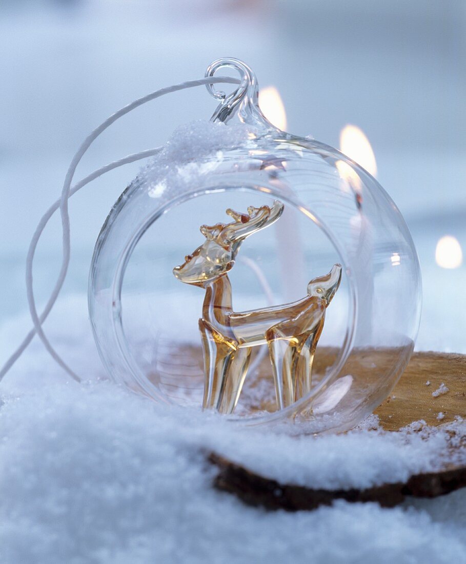 Weihnachtliche Dekokugel mit Rentier aus Glas im Kunstschnee