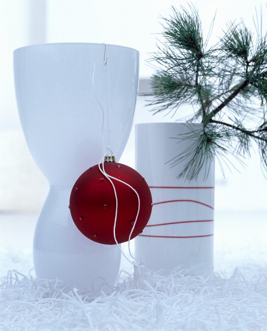 weiße elegante Vasen dekoriert mit roter Baumkugel