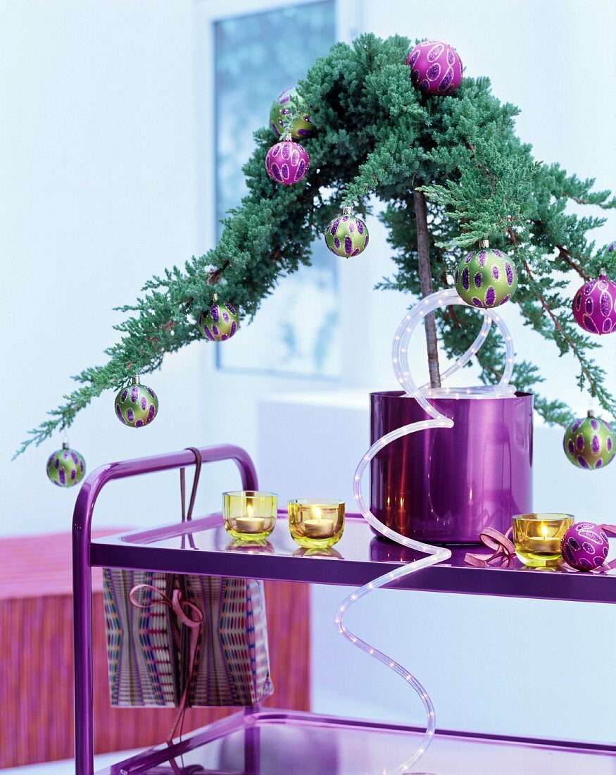 Small conifer in pink pot decorated with baubles