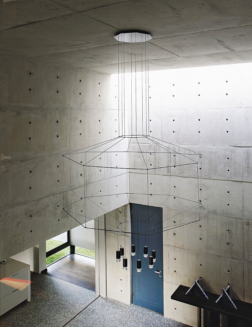 Imposanter Kronleuchter mit geometrischer Silhouette im Architektenhaus aus Beton