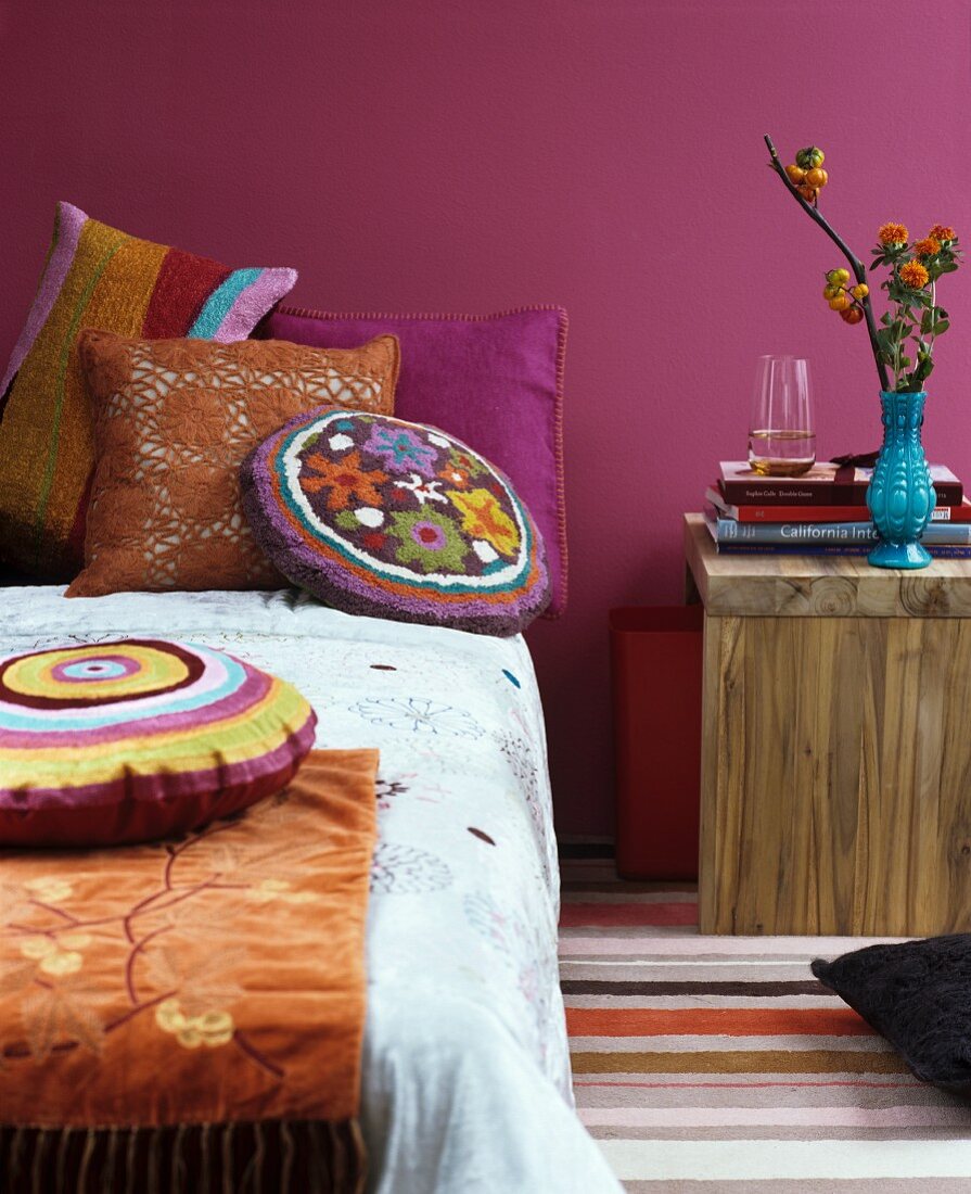 Indian Summer im Schlafzimmer: Bett dekoriert mit farbenfrohen Chenille- und Häkelkissen