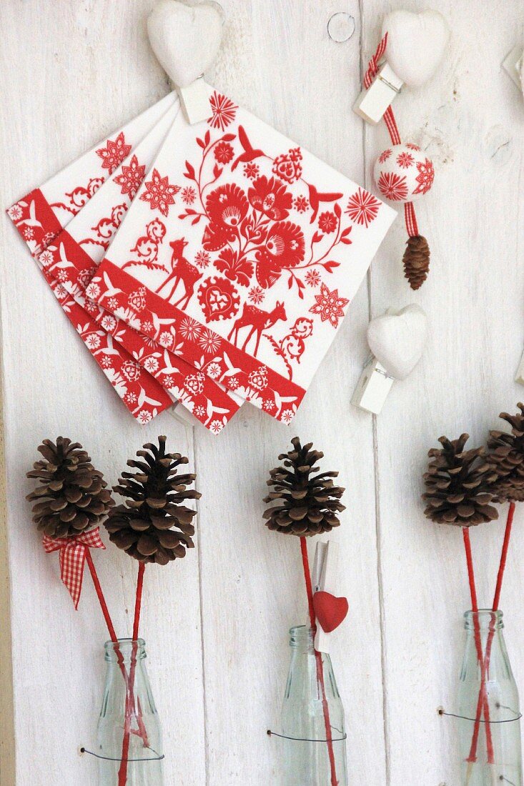 Weihnachtliche Dekoration mit Servietten, Dekoherzen & Kiefernzapfen