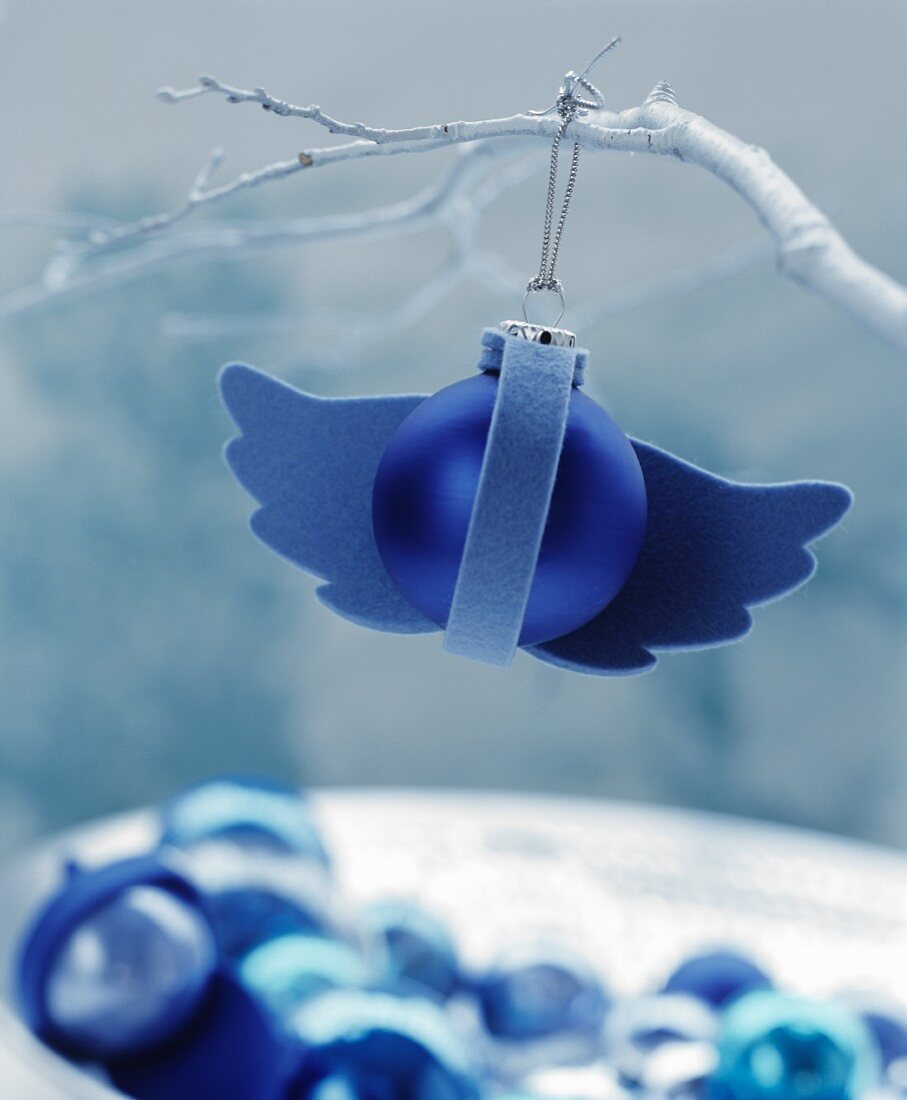 Blaue Christbaumkugel verziert mit Flügeln aus Filz