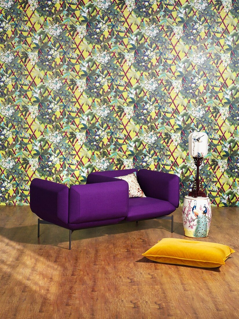 Purple designer armchair, yellow cushion and Chinese porcelain against patterned wallpaper