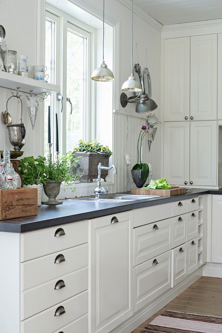 White country-house kitchen with panelled fronts and wainscoting
