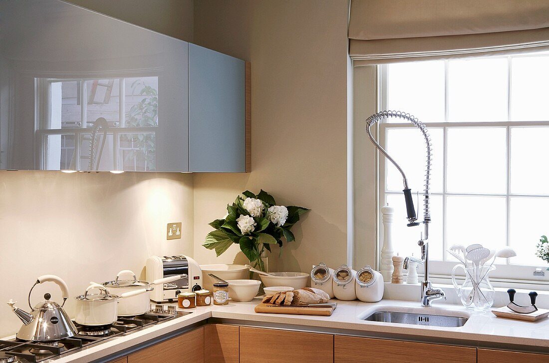 Fitted kitchen with gastro tap fittings, wall units with grey, glossy fronts
