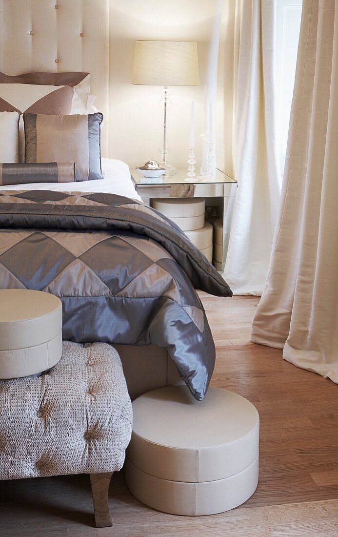 Elegant, grey bedlinen made from two-tone, plain chintz and hat box on bedroom bench in elegant bedroom