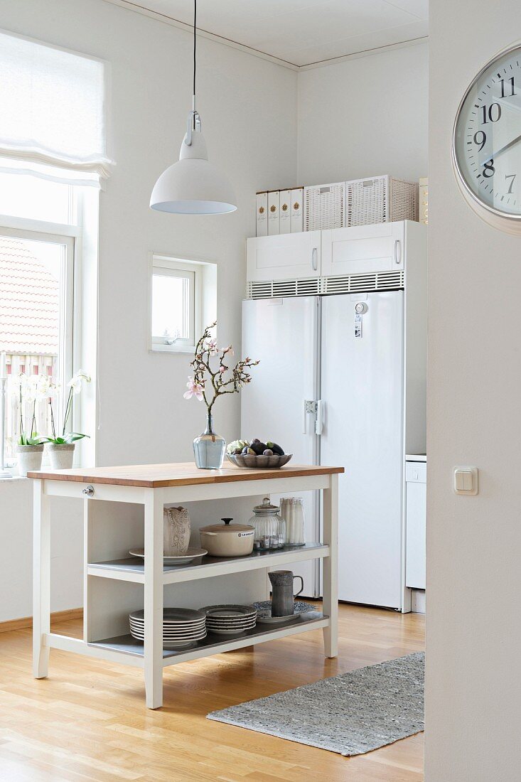 Helle Küche mit Kücheninsel und zweitürigem Kühlschrank