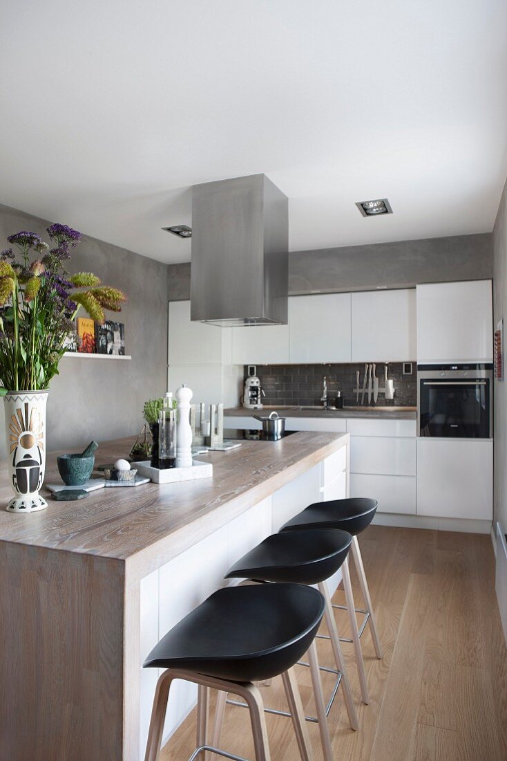 Moderne Küche mit Kochinsel und Barhocker, Wände in Beton-Optik