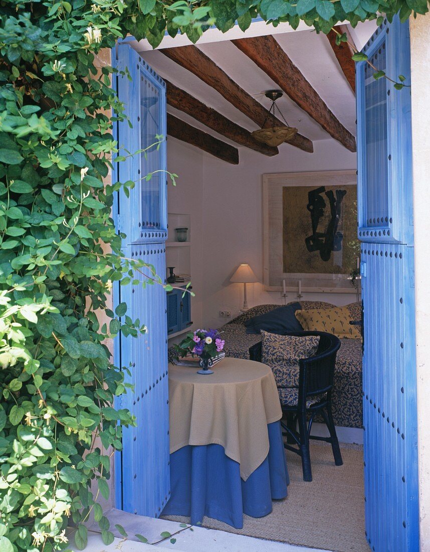 Blick durch offene, blau gestrichene Tür ins Wohnzimmer