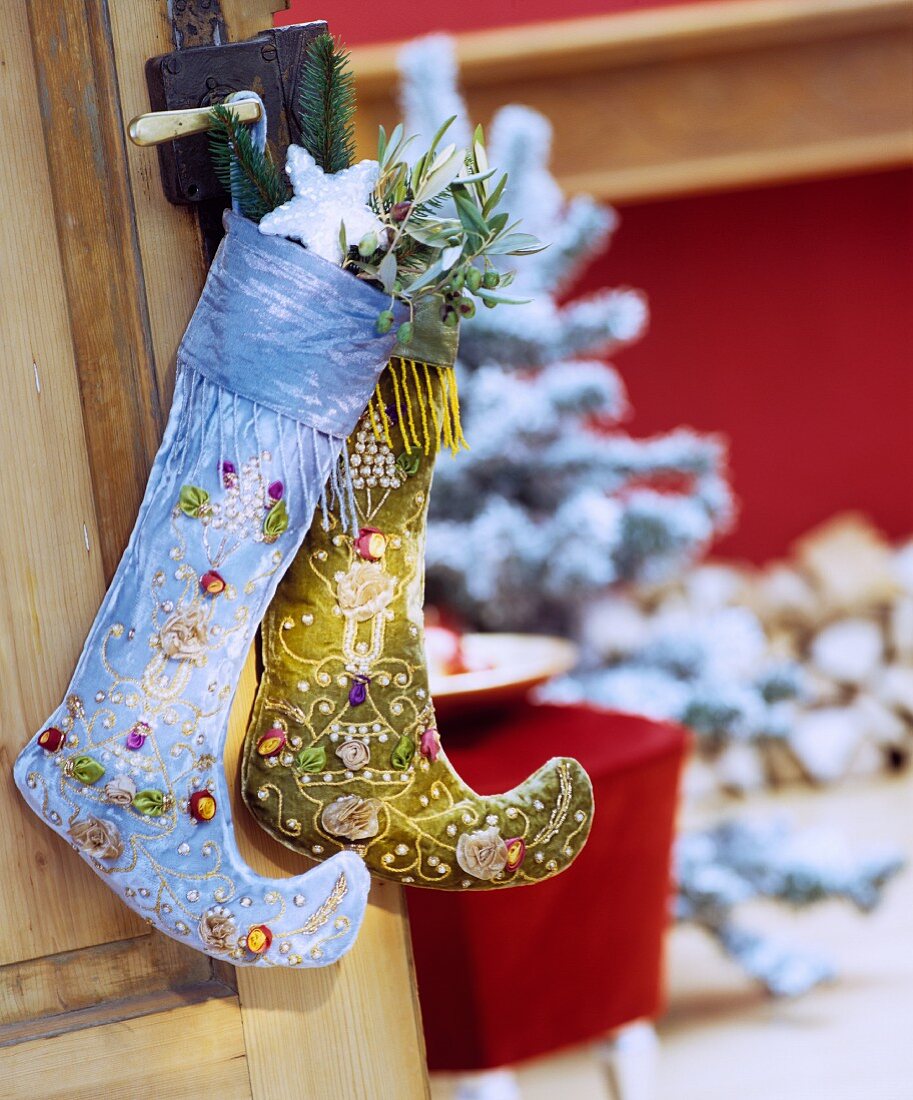 Two decorative Christmas stockings hanging from doorknob