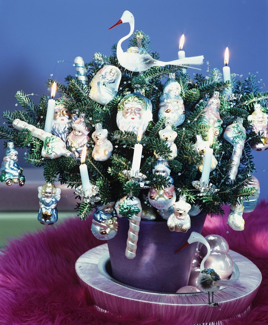 Tannenbäumchen üppig dekoriert mit brennenden Kerzen & Baumanhängern