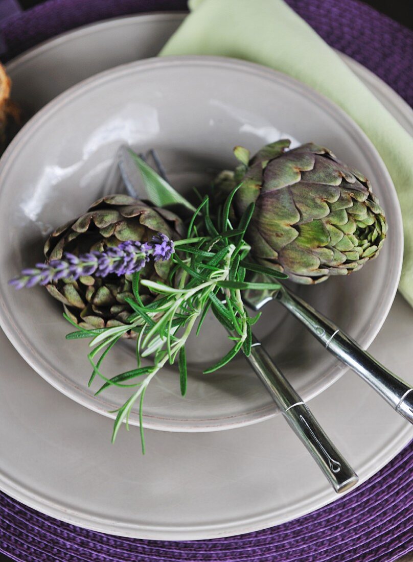 Place setting decorated with artichokes & sprig of rosemary