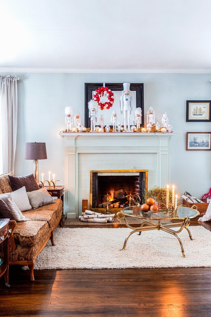 Sofa next to fireplace festively decorated with white nutcracker figurines