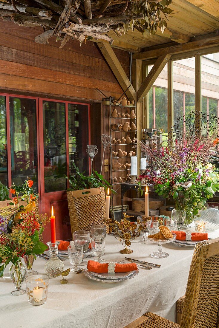 Autumnal dining table in conservatory with board wall