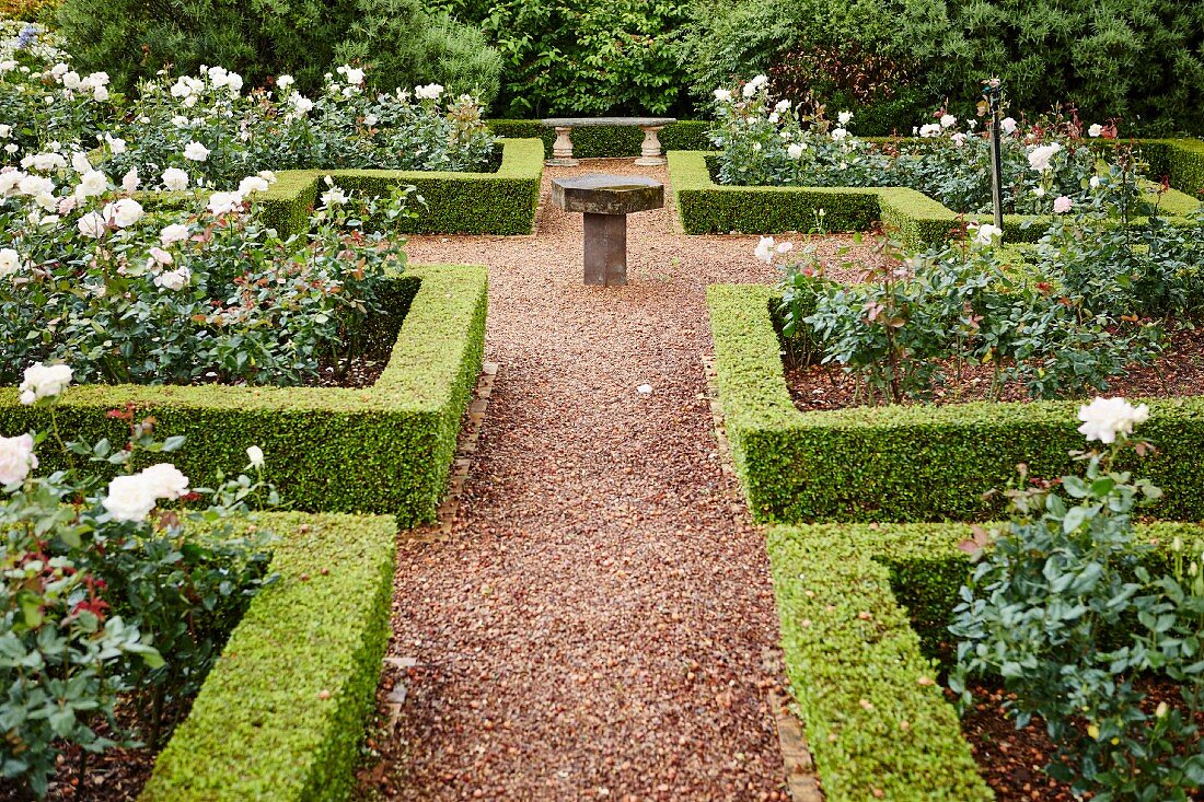 Gartenanlage mit geschnittenen geometrischen Hecken um Rosenrabatten in englischem Stil