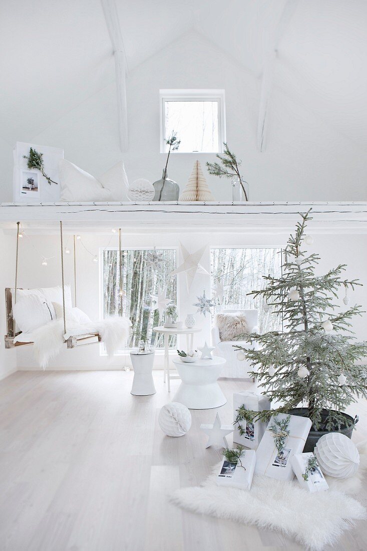 weiße Weihnachtsdekoration mit Tannenbaum und Zweigen in weißem Ambiente