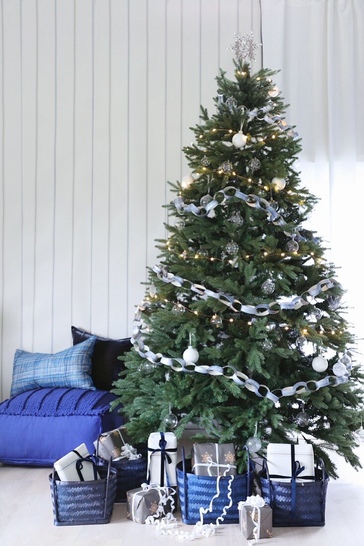 Geschmückter Weihnachtsbaum mit Geschenken in blauen Körben