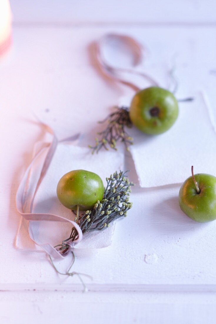 Grüne Äpfelchen mit Zedernästchen als winterliche Tischdekoration