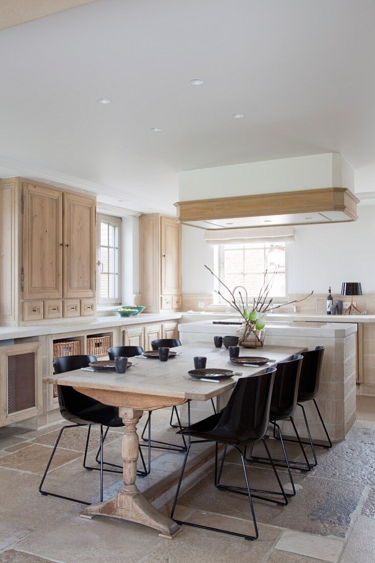 Country-house kitchen with wooden fronts, wooden table and modern chairs