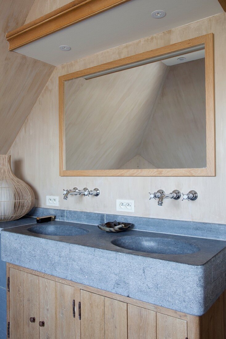 Solid stone washstand counter with recessed sinks on top of wooden cabinets