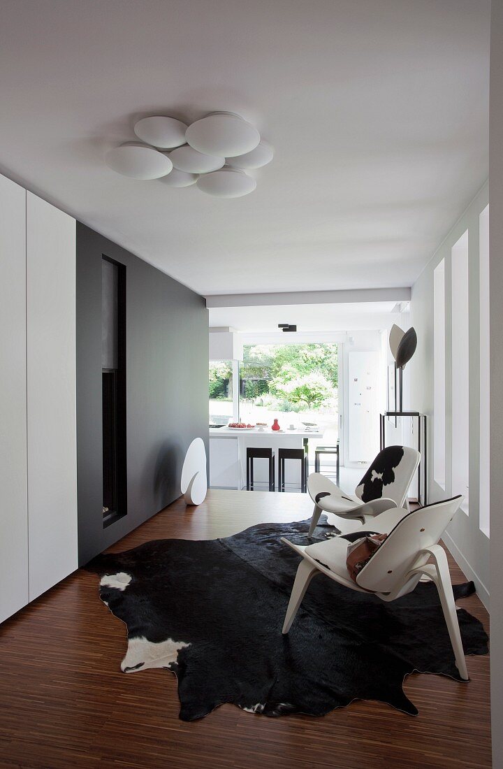 Klassikersessel auf grossem schwarzem Tierfellteppich in Designer-Wohnzimmer