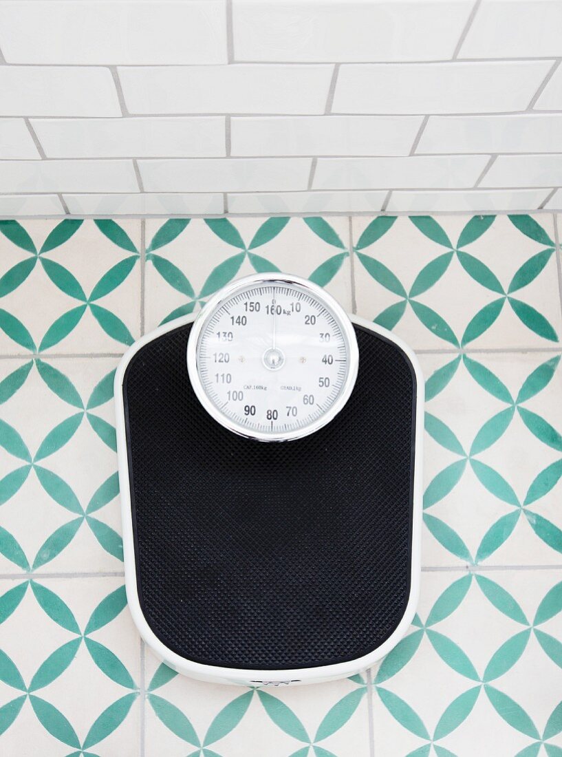 Bathroom scales on green and white patterned floor tiles