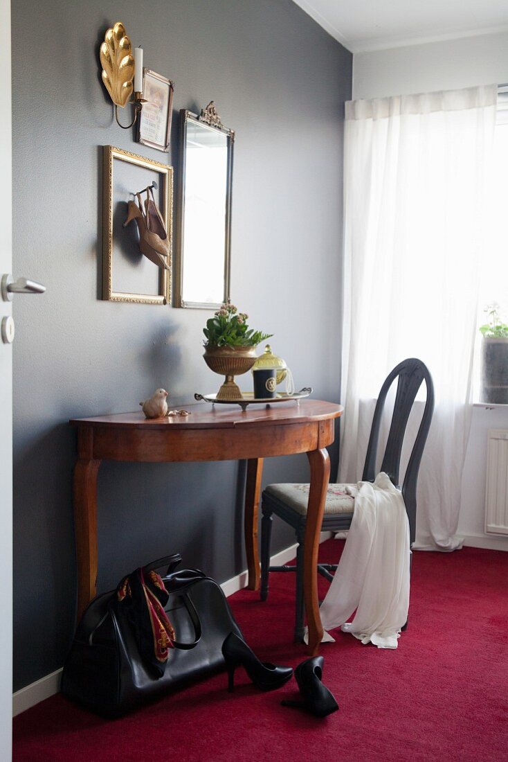 Dressing table against black wall in vintage-style bedroom