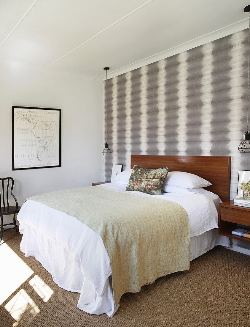 Dezentes Schlafzimmer mit grau-weißer Mustertapete und gerahmter Landkarte