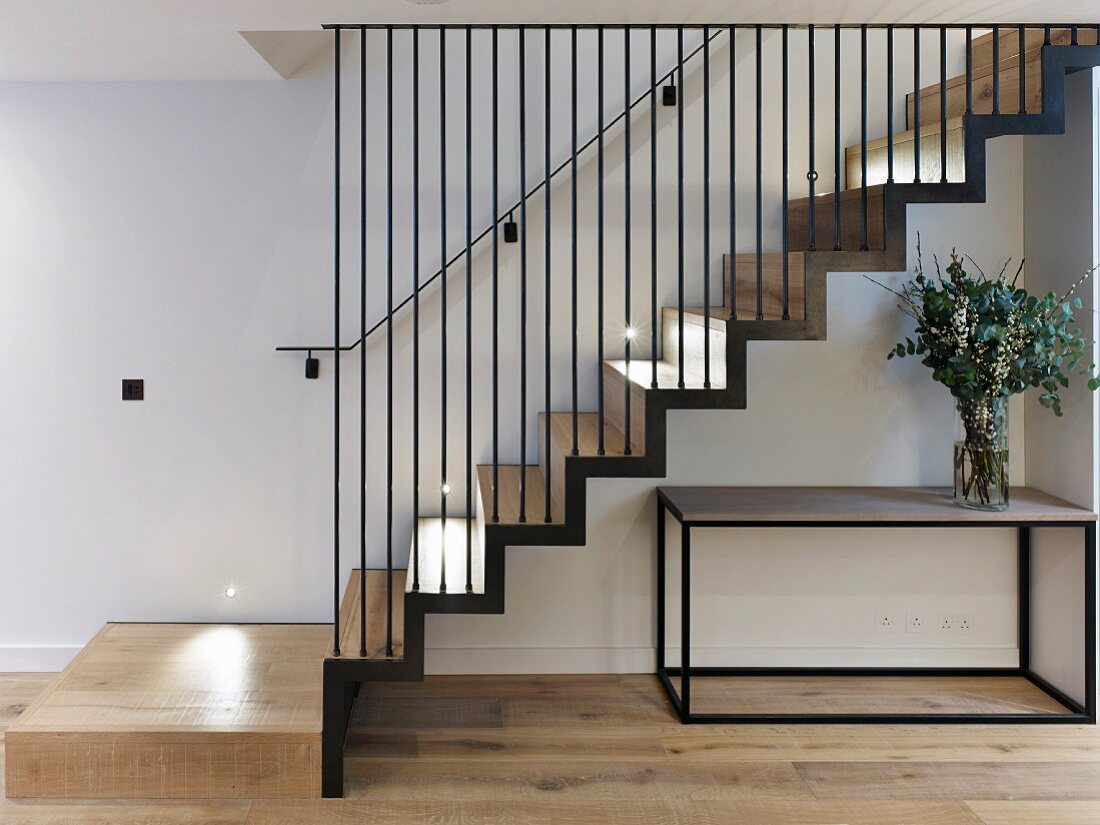 Cubist table below modern staircase with iron-rod balustrade
