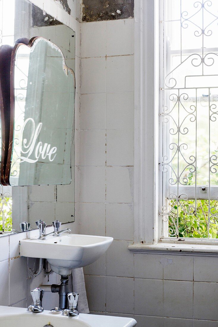 Nostalgisches Bad mit Fenstergitter und altem Spiegel